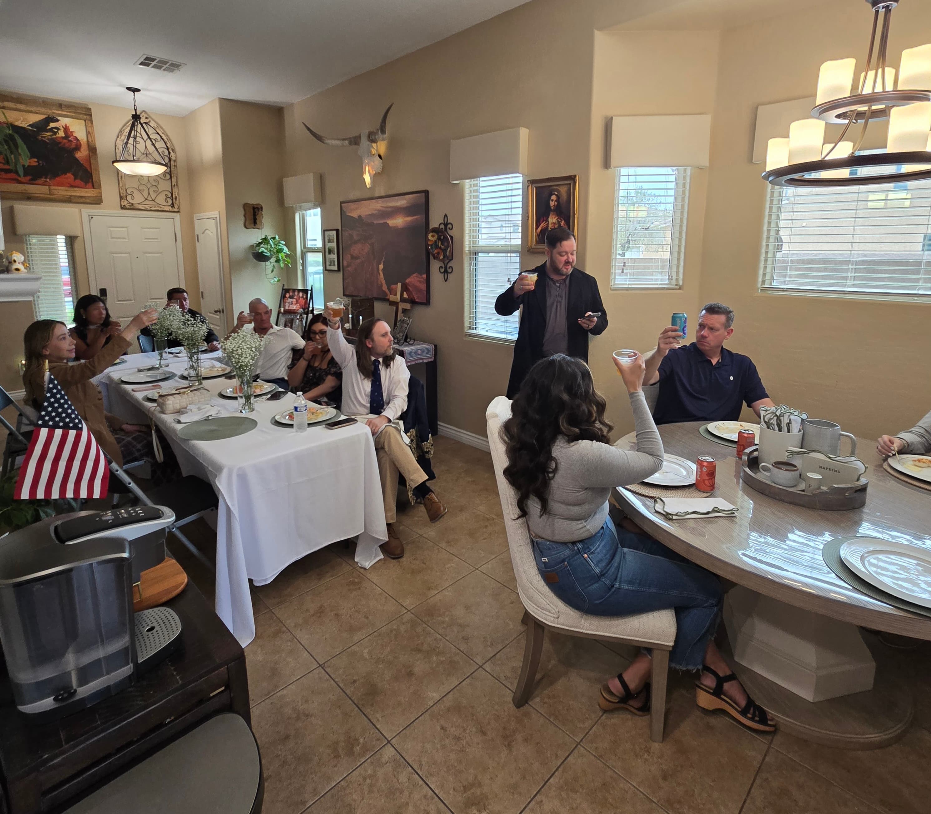 Guests raise a glass during remarks at the table